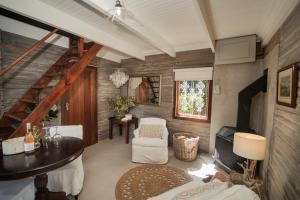 un soggiorno con tavolo, sedie e scala di Viewpoint Estate Accommodation a Haenertsburg
