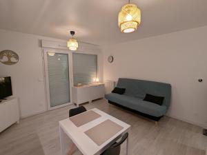 a living room with a couch and a table at Studio Les Capucines in Bretteville-sur-Odon +2 photos