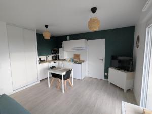 a kitchen with a table and a chair in a room at Studio Les Capucines in Bretteville-sur-Odon