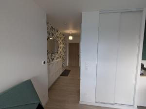 a hallway with white walls and a sliding door at Studio Les Capucines in Bretteville-sur-Odon