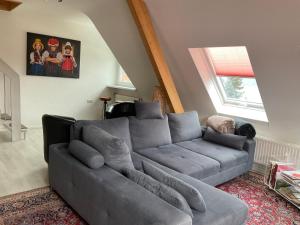 a living room with a gray couch and a window at Ferienwohnung Holzer am Titisee in Titisee-Neustadt