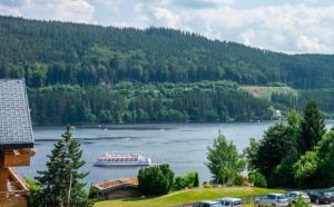 a boat on a river with a mountain at Ferienwohnung Holzer am Titisee in Titisee-Neustadt