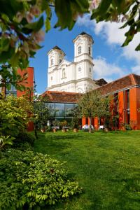 un gran edificio blanco con una torre en la parte superior de un patio en Der Ederer en Weiz