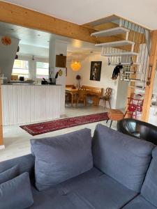 a living room with a blue couch and a kitchen at Ferienwohnung Holzer am Titisee in Titisee-Neustadt +10 photos