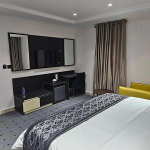 a hotel room with a bed and a television at Anibex Luxe Apartment in Abuja