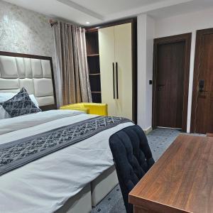 a bedroom with a large bed and a wooden table at Anibex Luxe Apartment in Abuja