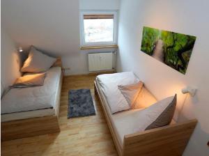 a small room with two beds and a window at Ferienwohnung Holzer am Titisee in Titisee-Neustadt