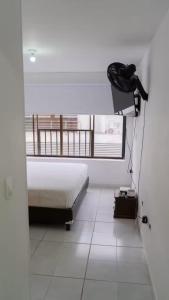 a white room with a bed and a window at 3 habitaciones Cabecera del LLano in Bucaramanga