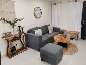 a living room with a couch and a table and a clock at La Bella Suite in San Salvador