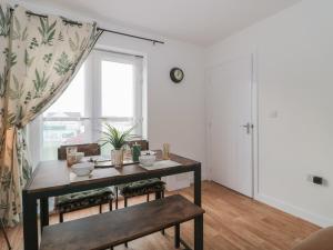 a living room with a table and a window at Cotswold Outlet Coach House in Tewkesbury +19 photos
