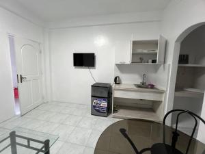 a white living room with a glass table and a sink at Bianco 305 in Angeles