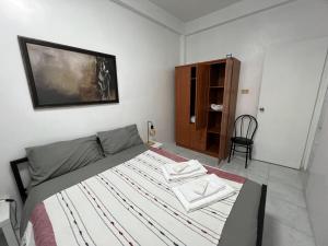 a bedroom with a bed with two towels on it at Bianco 305 in Angeles