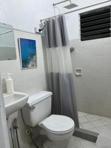 a bathroom with a toilet and a shower curtain at Bianco 305 in Angeles