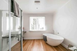 un bagno con una grande vasca bianca e una finestra di The Pear Orchard Lodge a Richmond