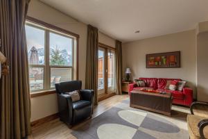 een woonkamer met een rode bank en 2 stoelen bij Fire Mountain Lodge in Canmore