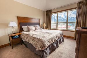 een slaapkamer met een bed en een groot raam bij Fire Mountain Lodge in Canmore