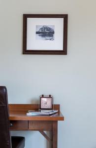 een laptop op een bureau met een foto aan de muur bij Fire Mountain Lodge in Canmore