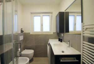 a bathroom with a sink and a toilet and windows at CASA 4 PIOPPI - Vista Lagorai e tranquillità a Cavalese - Dolomiti Affitti in Cavalese +54 photos
