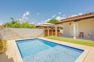 a swimming pool in the backyard of a house at GB115 Linda Casa 4 suítes a 250m da praia - Guarajuba in Camacari