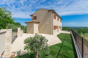 a white house with a fence and a yard at Villa Skarline in Donje Baredine
