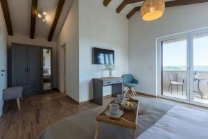 a living room with a table and a view of the ocean at Villa Skarline in Donje Baredine