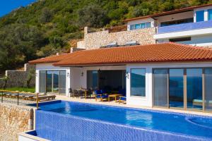 eine Villa mit einem Pool neben einem Haus in der Unterkunft Akasya Villas in Kalkan