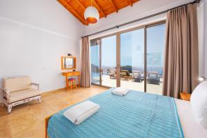 ein Schlafzimmer mit blauem Bett und Balkon in der Unterkunft Akasya Villas in Kalkan + 33 Fotos