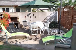 a patio with a table and chairs and an umbrella at Maison enchanteur à Berrwiller avec jardin paisible in Berrwiller