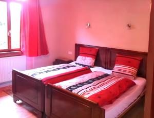 two beds in a bedroom with red walls at Maison enchanteur à Berrwiller avec jardin paisible in Berrwiller