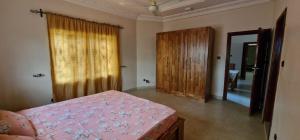 Abomey-CalaviにあるLa Maison de Roseのベッドルーム1室(ベッド1台付)、木製のドア