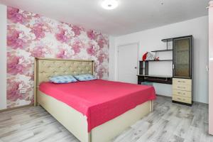 a bedroom with a bed with a pink floral wallpaper at Просторная квартира со свежим ремонтом in Pavlodar