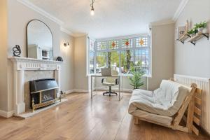 ein Wohnzimmer mit einem Kamin und einem Schreibtisch in der Unterkunft Luxury Birmingham Solihull Spacious Home - Driveway - Groups of 8 Max - 3 Bedrooms 4 or 6 Beds Fully Equipped Home - Near City Centre NEC HS2 Sites Edgbaston Moseley& lots more! in Birmingham