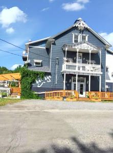 a large house with a porch and a balcony at Comfortable apartment Sainte-Angèle-de-Mérici 80 m² balcony! in Sainte-Angèle