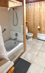 a bathroom with a tub and a toilet and a shower at Comfortable apartment Sainte-Angèle-de-Mérici 80 m² balcony! in Sainte-Angèle