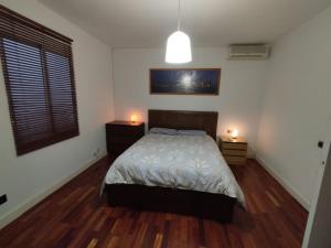 a bedroom with a bed and two lights on two tables at Apartamento supercéntrico "Tarraco Arena" con ascensor y parking incluído in Tarragona