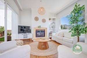 a living room with white furniture and a fireplace at Casa Lagarto - villa with pool and jacuzzi in Almuñécar