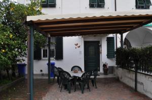 uma mesa e cadeiras sob toldo em frente a uma casa em Affittacamere Elisa em Pisa