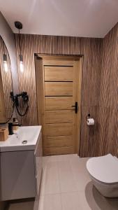 a bathroom with a toilet and a wooden door at Chałupka Apartament 3 in Krempachy +58 photos