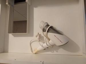 a hairdryer hanging on a wall in a bathroom at Klonowa 4 4 in Kamienna Góra