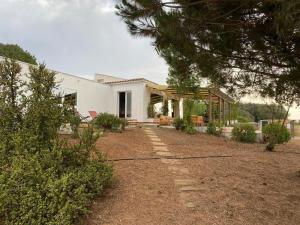 a white house with a garden in front of it at Casa Nika finca de campo Menorquina con piscina in Llumesanas
