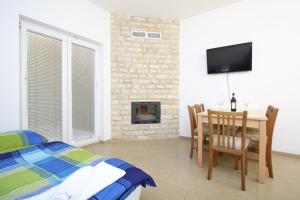 a bedroom with a bed and a table and a tv at Apartments Jasmina in Novalja