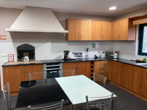 a kitchen with wooden cabinets and a table with chairs at Quinta de Santana - Queimadas in Furnas
