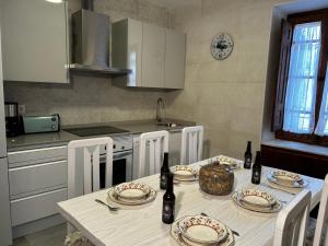 a kitchen with a table with plates and bottles on it at El tejo milenario in Requejo