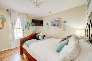 a bedroom with a bed with a television on the wall at Pet-Friendly Home with Private Hot Tub in Wilmington in Wilmington