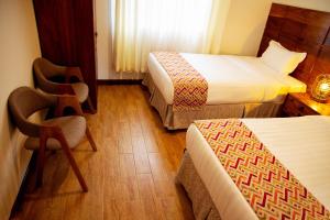 a hotel room with two beds and two chairs at Iwandaa Lodge And Apartments in Sokon
