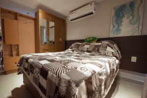 a bedroom with a bed with a black and white blanket at Apto c otima localizacao a 120m da praia de Tambau in Tambaú +21 photos