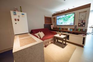 a living room with a red couch and a flat screen tv at Apto c otima localizacao a 120m da praia de Tambau in Tambaú