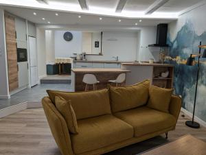 een woonkamer met een bank en een keuken bij Maison chaleureuse au cœur du centre ville in Pornic