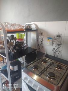 a kitchen with a stove and a shelf with dishes at Casa meu canto in Lençóis +12 photos