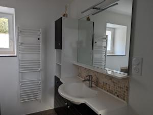 een witte badkamer met een wastafel en een spiegel bij Maison chaleureuse au cœur du centre ville in Pornic +19 foto's